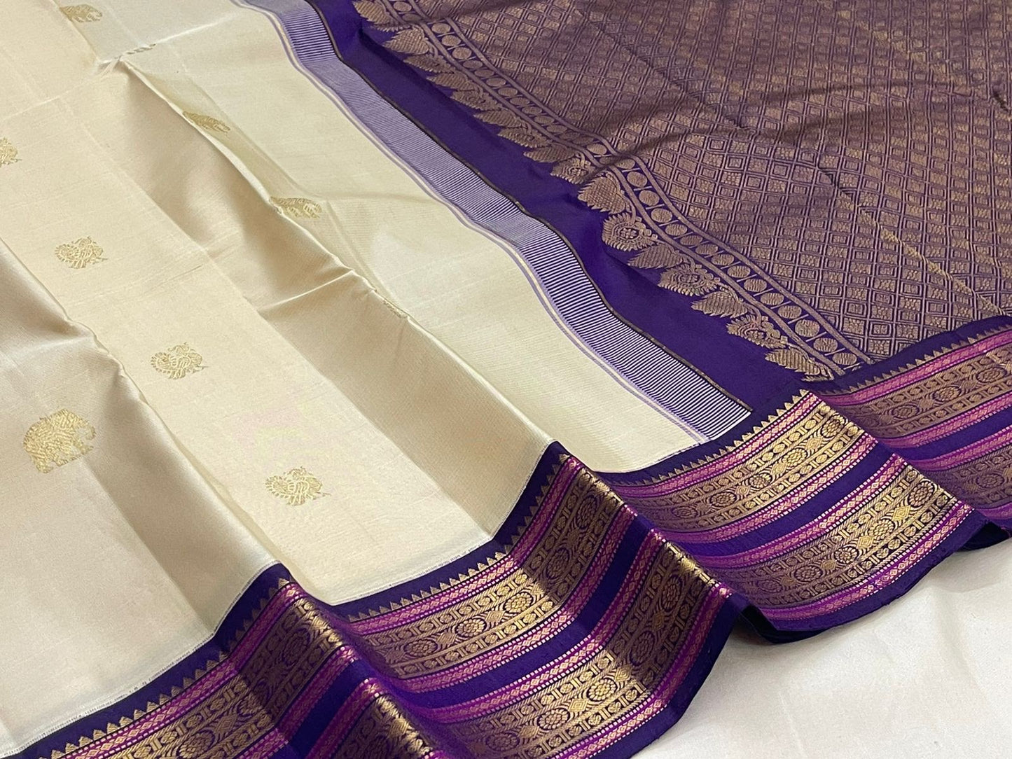 Gold zari elephant motif close-up on off-white body