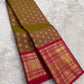 Traditional small peacock buttas woven across the muted olive and brown silk body.
