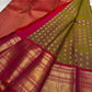 Contrast between olive-bronze body, ruby-red pallu and richly framed gold zari border.