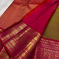 Unfolded olive-brown silk body with gold peacock buttas and a richly patterned ruby-pink border.