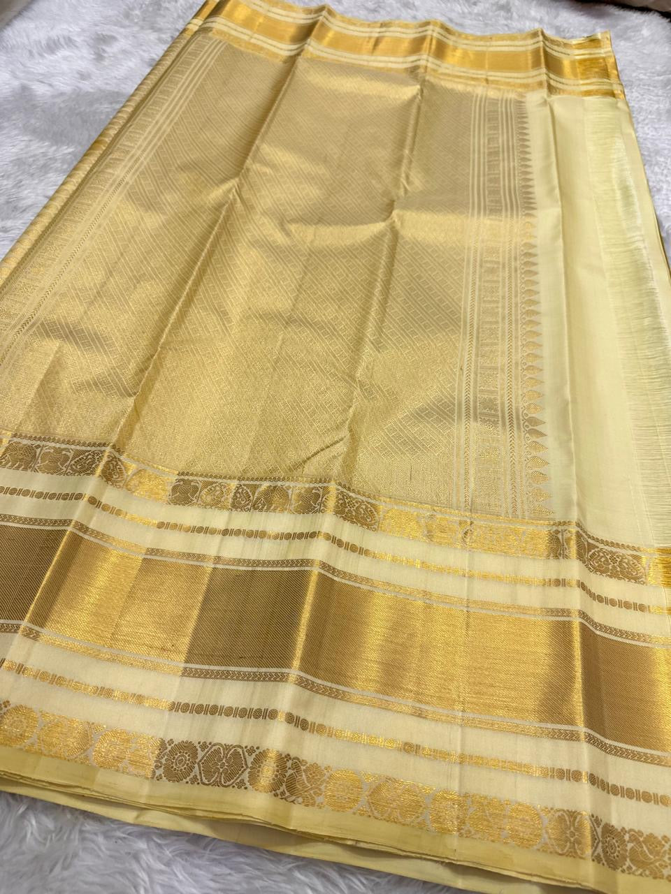 Olive Turmeric Gold Kanchipuram silk contrasted with luminous jasmine-ivory Paal Vellai and warm gold zari.