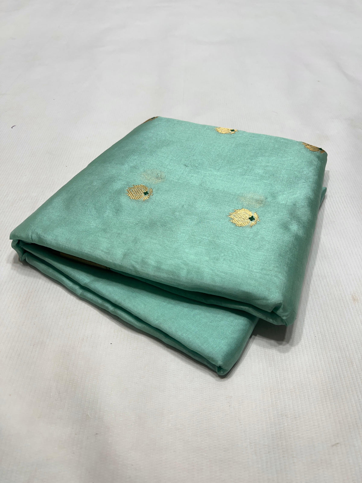 Detail of the slender Olive Green edge finishing the gold border on an Aqua Blue Chanderi silk saree