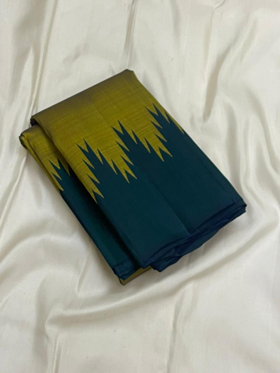 Folded Pure Kanchipuram Silk Saree in olive green with forest green Thazampoo Reku border on white background