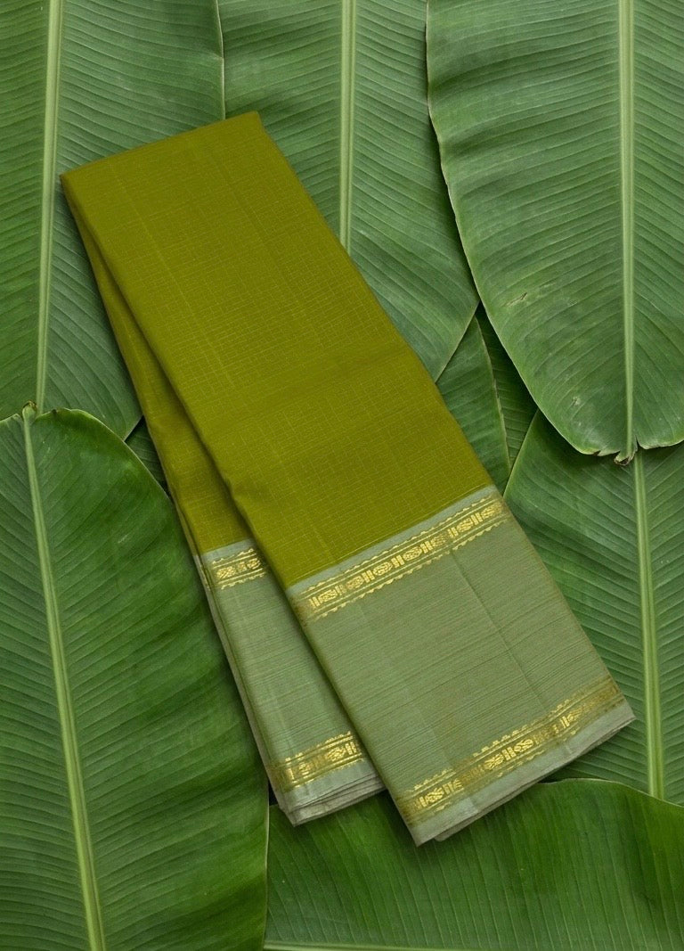 Olive green handwoven Kancheepuram pure silk saree with zari kattam body and sage korvai border on banana leaf — Idam Living