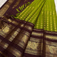 Broad deep plum-brown border showing a repeated array of peacocks in warm gold zari.