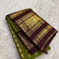 Handwoven olive-green Kanjivaram silk with contrasting plum-brown border and gold zari detail.