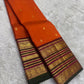 Close-up of orange silk body with scattered gold zari butta motifs on pure mulberry silk