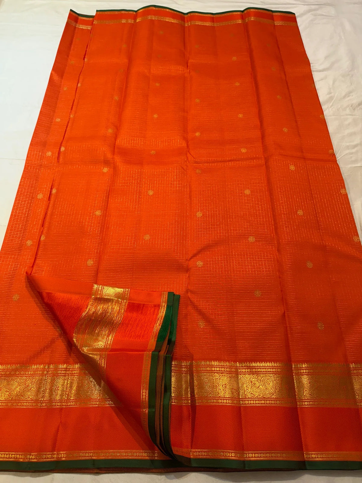 Restrained circular gold-zari butta within the fine grid.