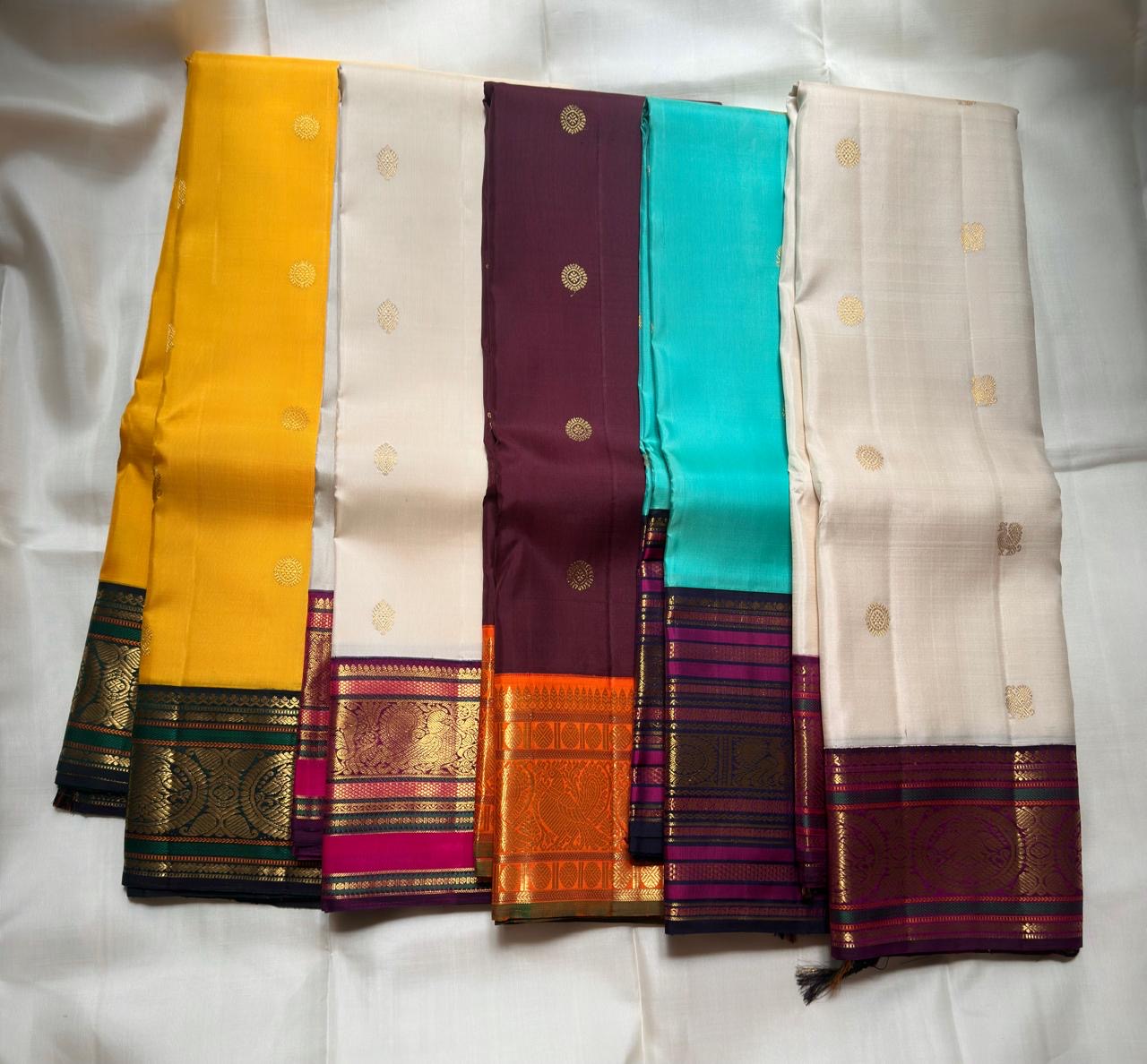 Kanchana Brown and orange pure silk saree showing broad gold zari peacock border.