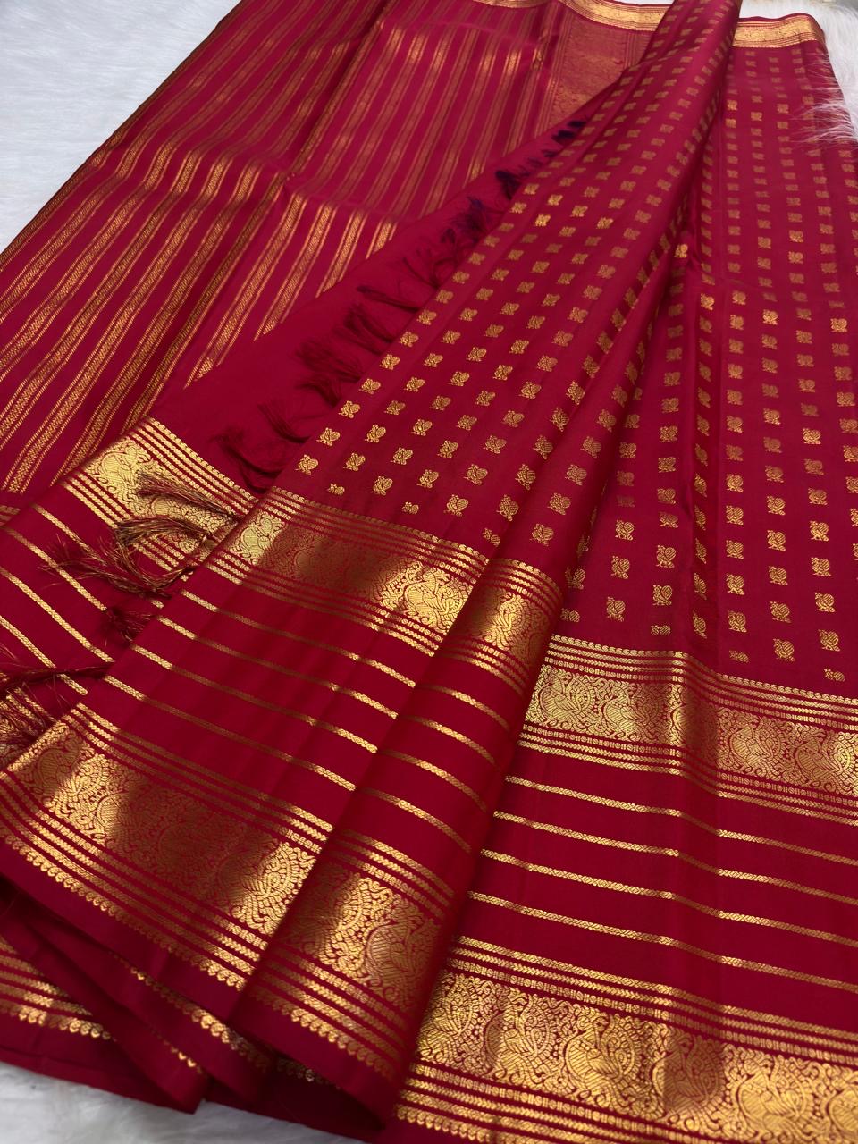 Warm gold pallu on the vermilion Kanchipuram saree.