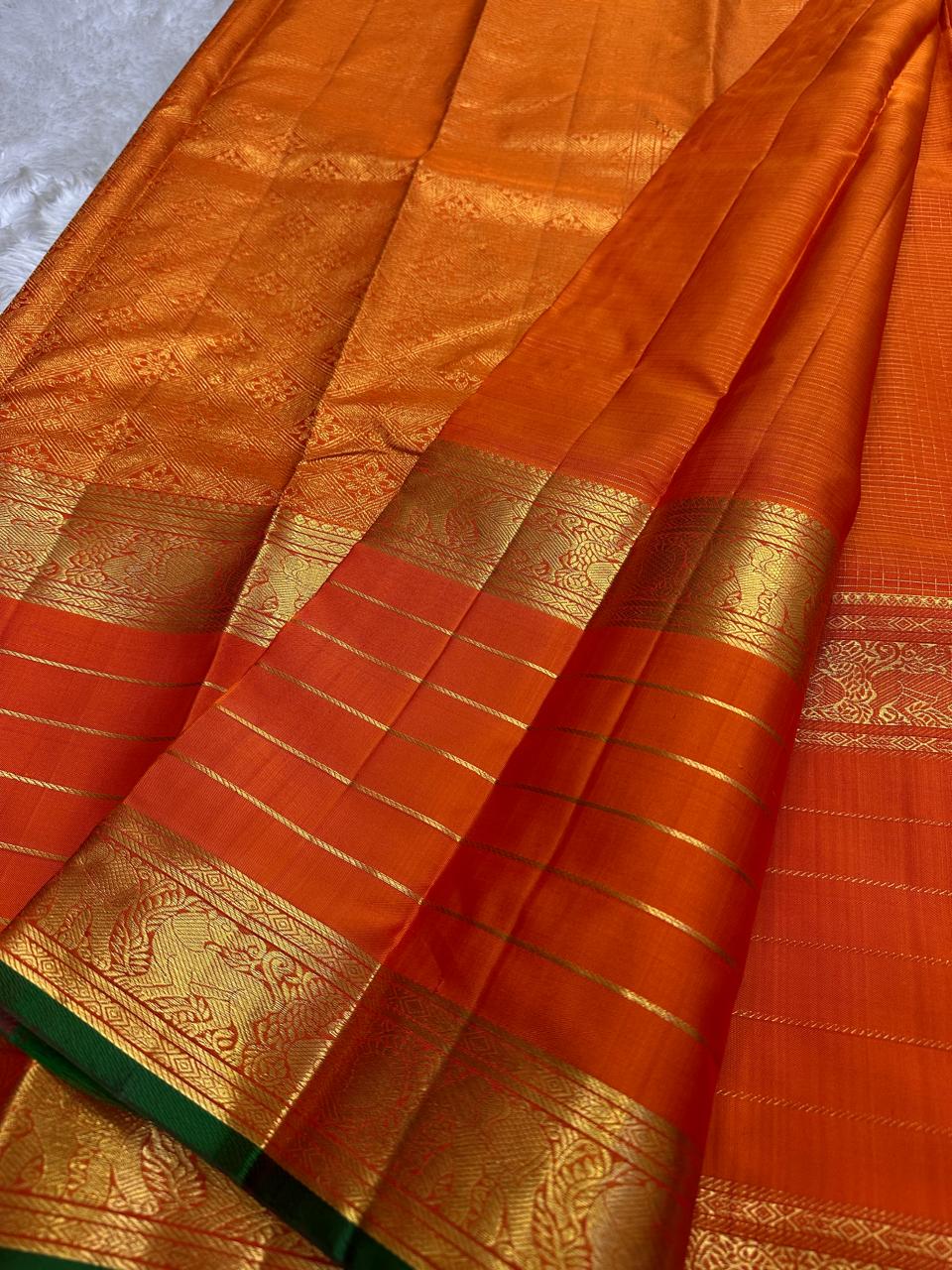 Spread pure Kanchipuram silk saree showing gold zari border, striped body and green edge, shipped from New Jersey USA
