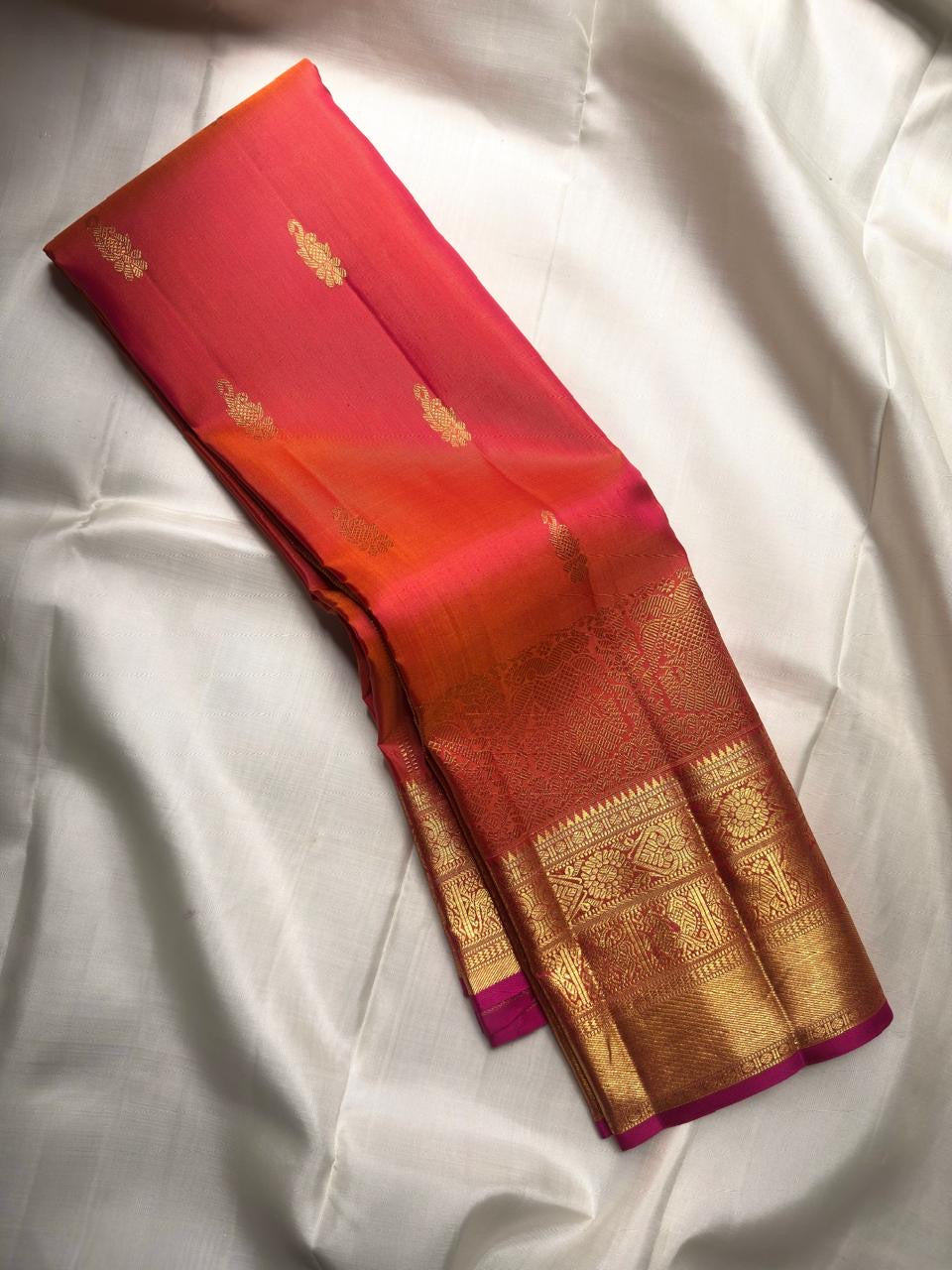 Handwoven orange Kanjivaram silk saree with Rani-pink edge and richly woven Thanga-zari Mayil border