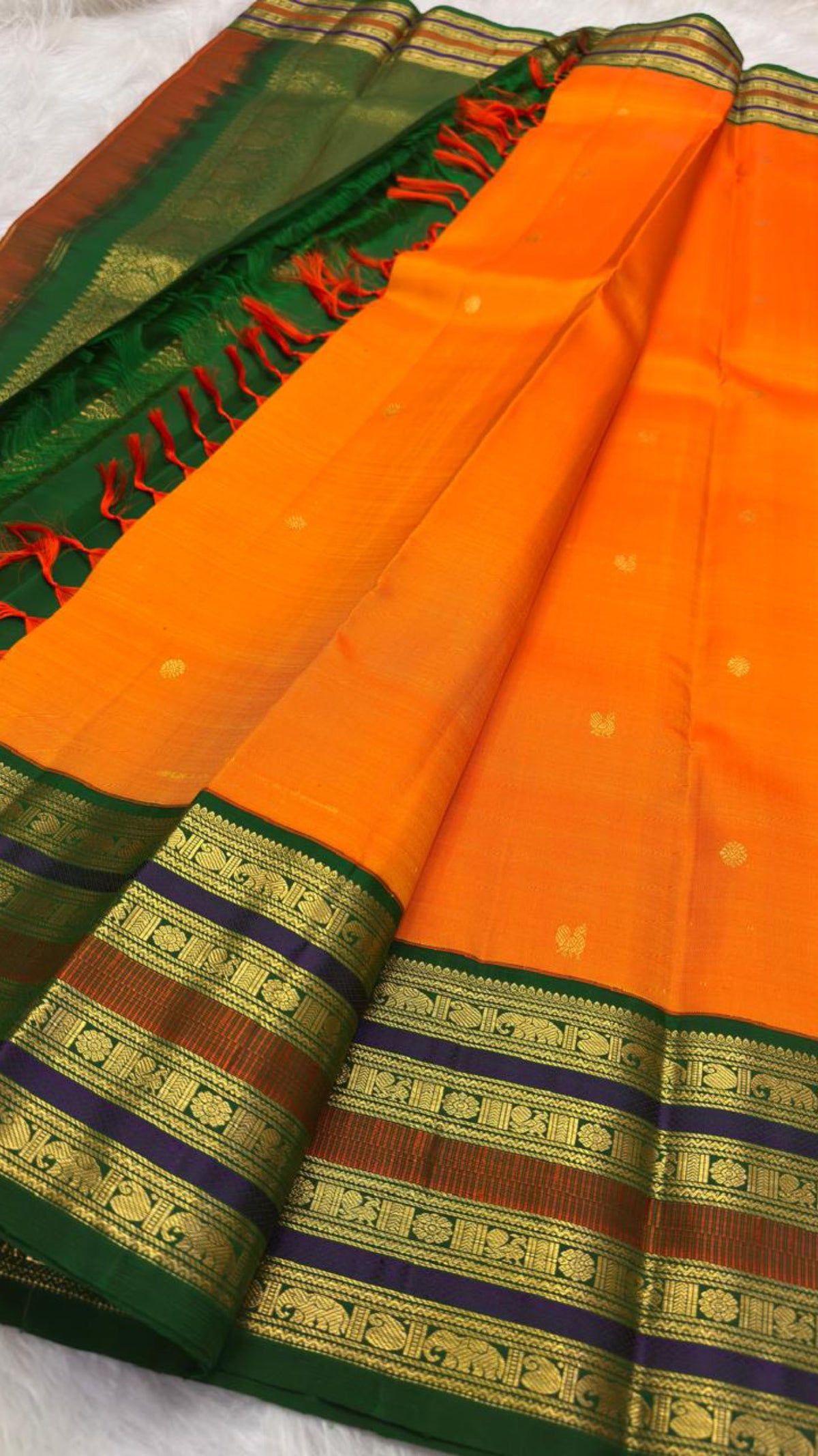 Orange Pure Silk Kanjeevaram saree showing the Maragatham green layered border against the marigold body.