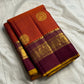 Folded rust orange Pure Kanchipuram silk saree with deep purple border and gold zari woven detailing