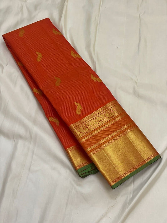 vermillion orange kanchipuram silk saree body with gold paisley buttas