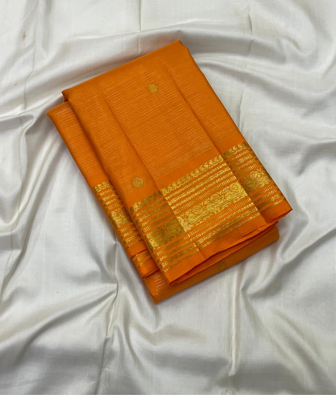 Handwoven Saffron Orange Kanchipuram saree with parallel Vairaoosi zari lines and gold border.