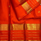 Varisaipet border of handwoven zari and thin zari bands on a radiant jewel-toned orange Kanchipuram silk saree.