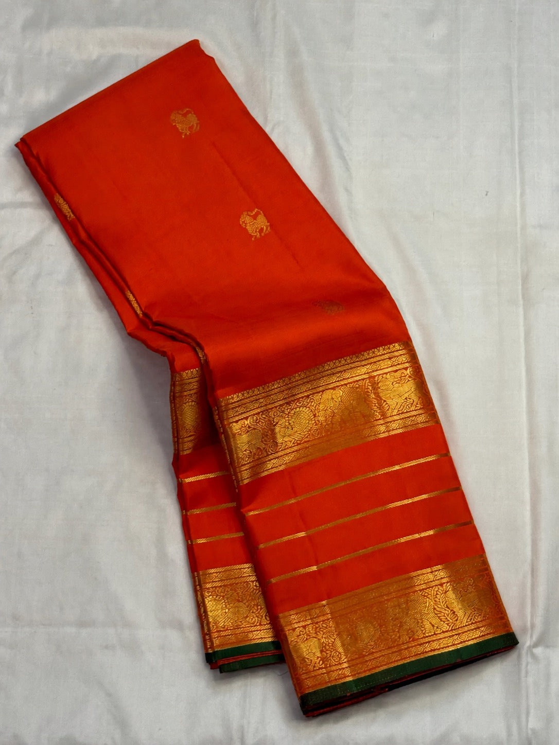 Radiant jewel-toned orange Pure Silk Kanchipuram Varisaipet saree with luminous body and traditional border bands.