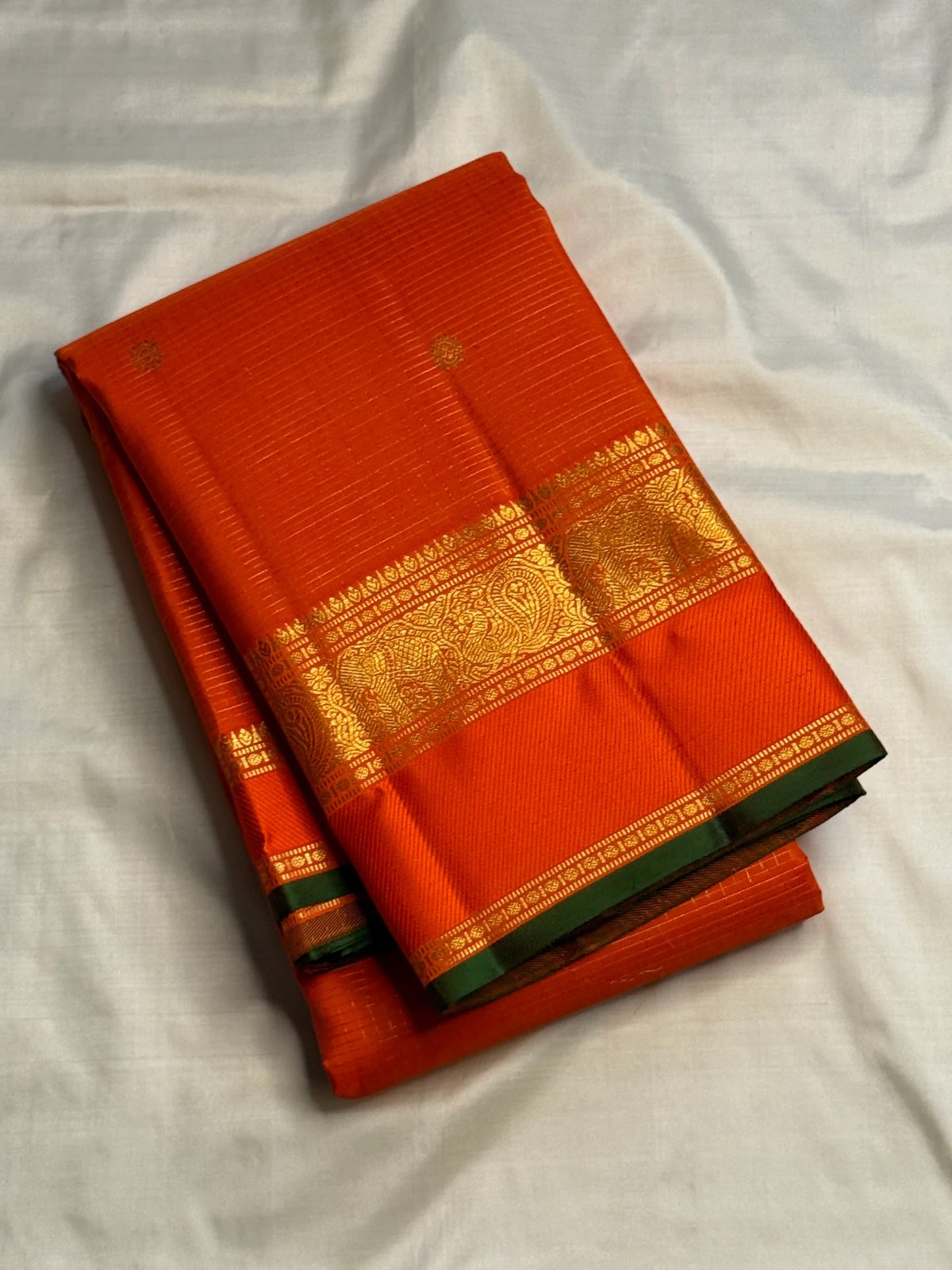 Fine gold hairline Kattam across vivid Orange silk.
