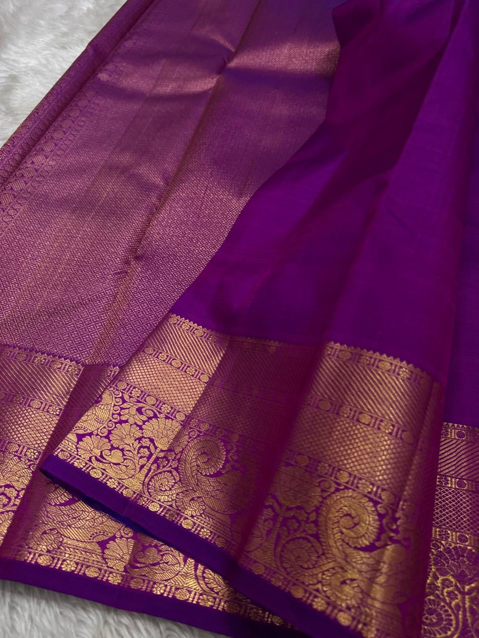 Gold zari border detail on an orchid purple Kancheepuram silk saree