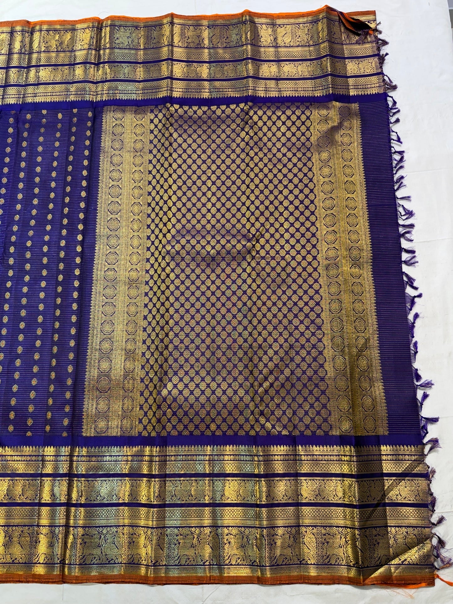 Broad gold zari border detail with multiple ornamental registers separated by violet silk lines