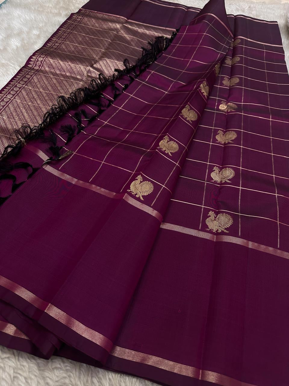 Plum Pure Kanchipuram silk saree with zari checked grid and woven motifs beside a zari-woven pallu and black tassels, shipped from New Jersey USA.