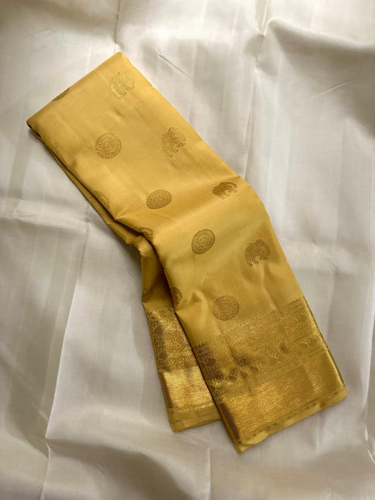 Close folded view showing alternating gold zari buttas across the Butter Yellow silk body