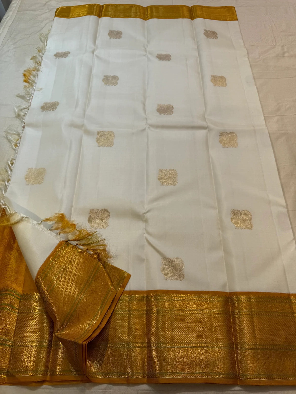 Close view of handwoven Mayil zari buttas on Warm Ivory silk