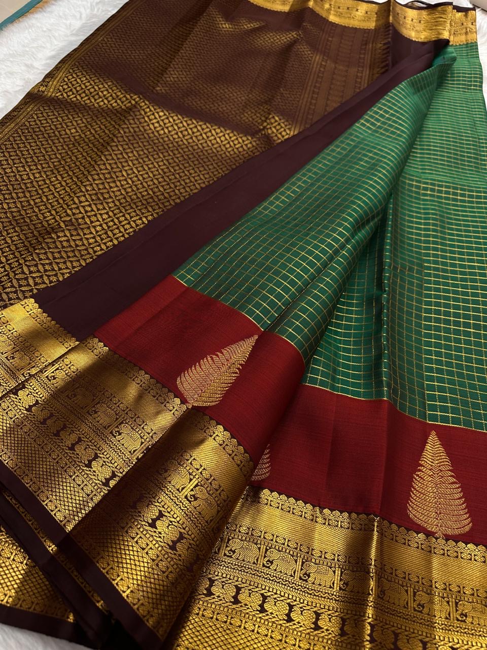 Paaku Brown border with classic-gold zari ornamental bands on the Maragatham Green Kanchipuram.