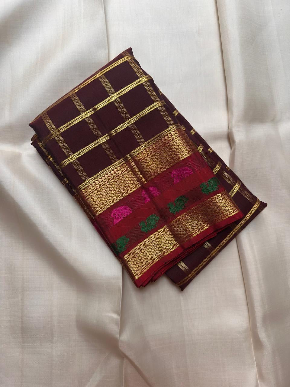 Dark aubergine-maroon Kanchipuram body with fine restrained classic gold zari Kattam checked framework.