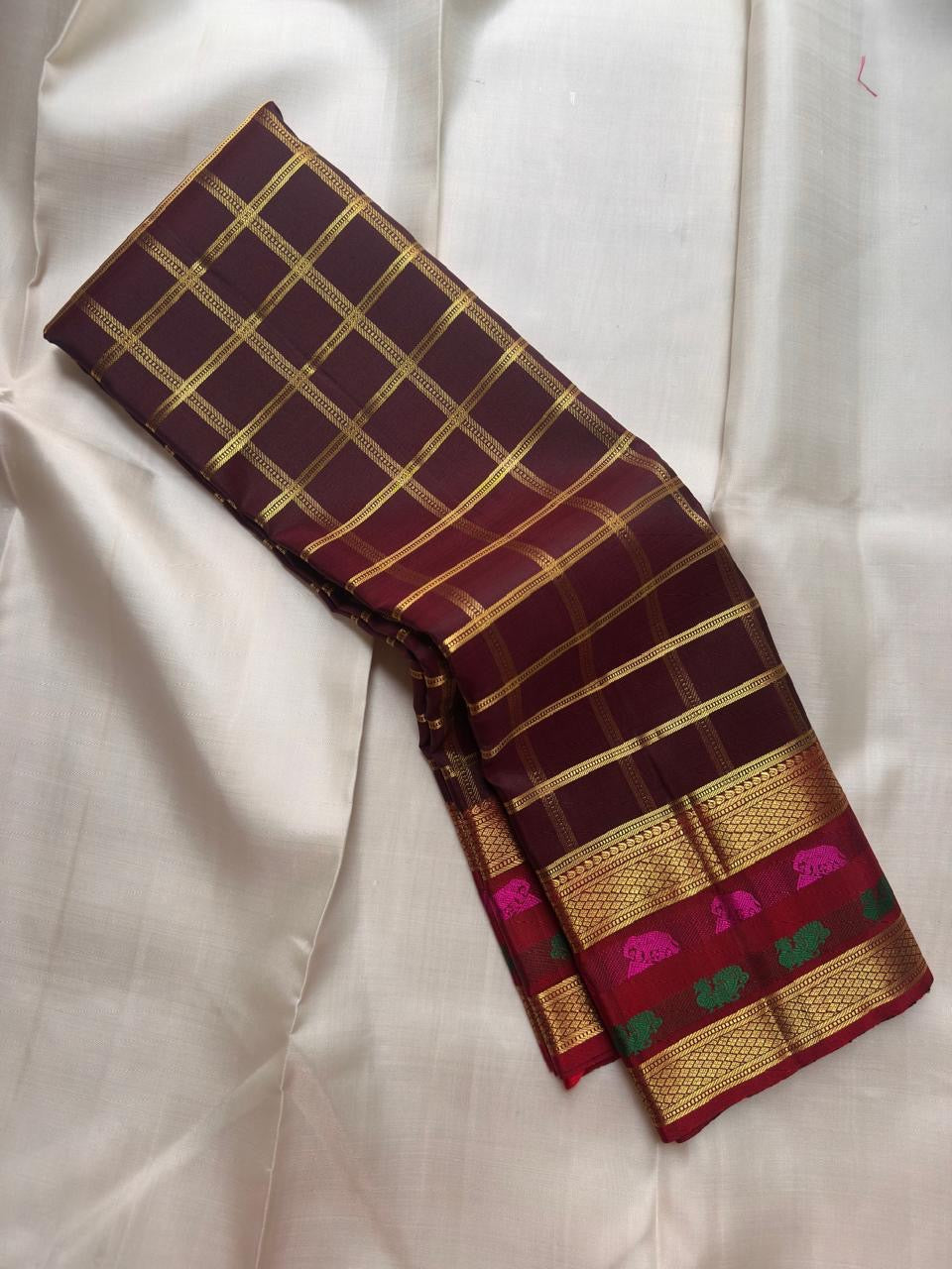 Paaku Brown pure silk Kanchipuram Zari Kattam saree with Arakku border and vivid Rani Pink Yaanai motifs.