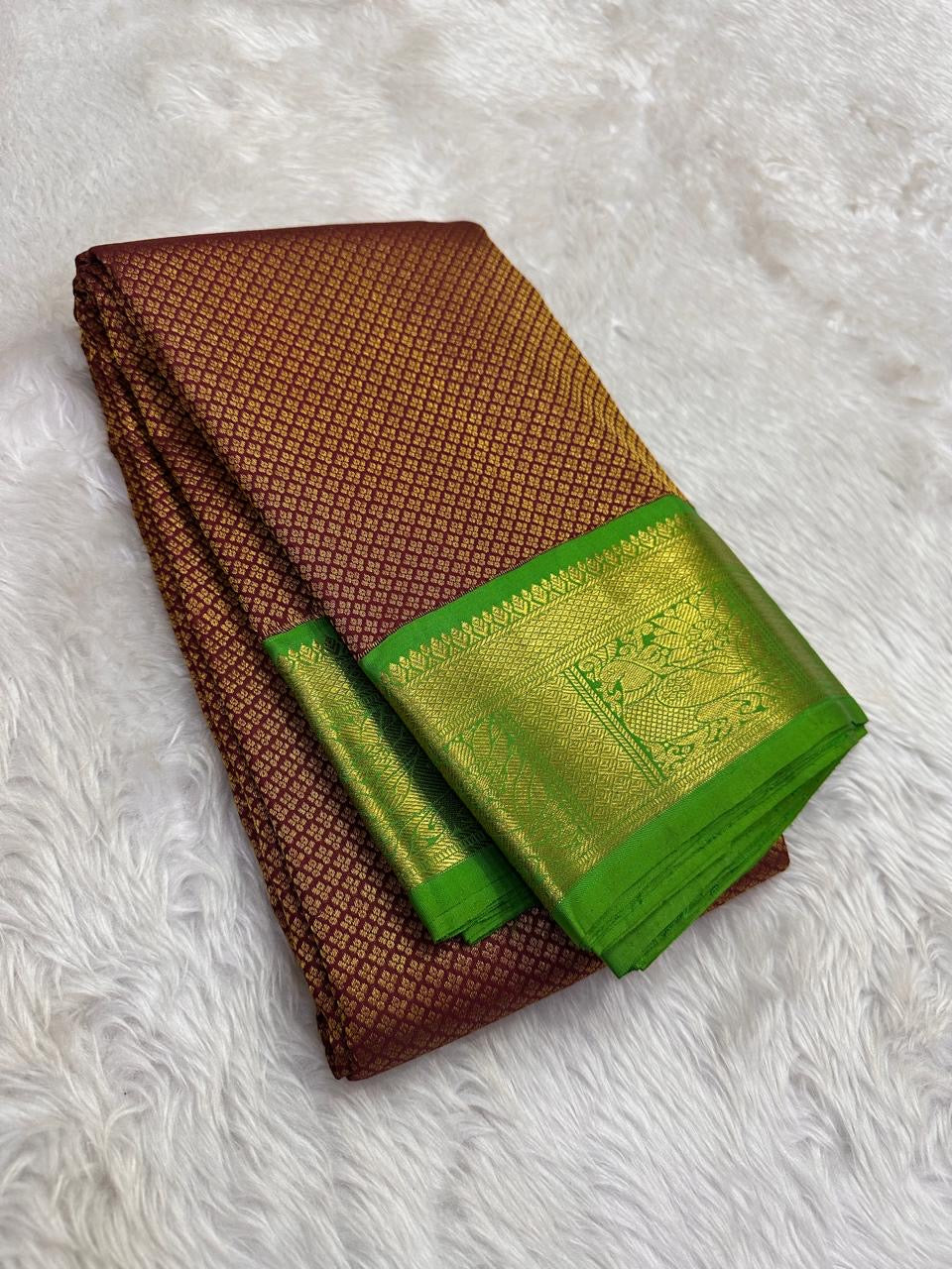 Expanded kili pachai green pallu showing rows of gold circular motifs and ornate traditional registers