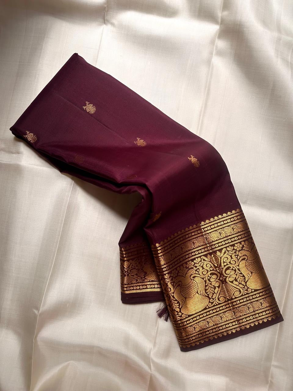 Small classic-gold zari buttas spaced across deep reddish Paaku Brown silk.
