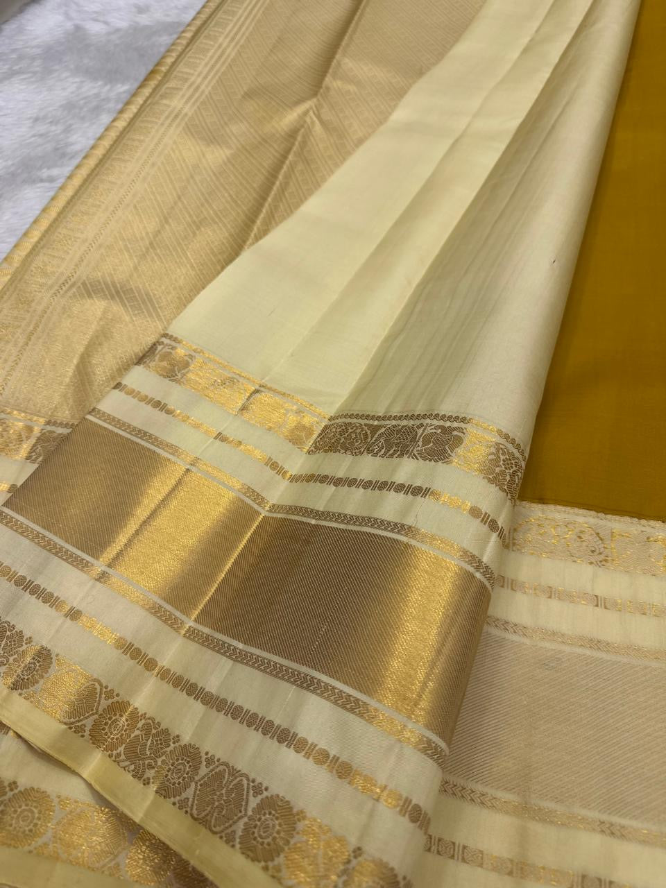 Paal Vellai ivory Korvai border with broad gold-zari registers, floral medallions and geometric detailing.