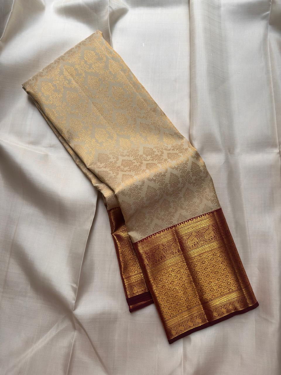 Soft pearl-ivory Kanchipuram silk body with restrained spacing of traditional classic gold zari buttas.
