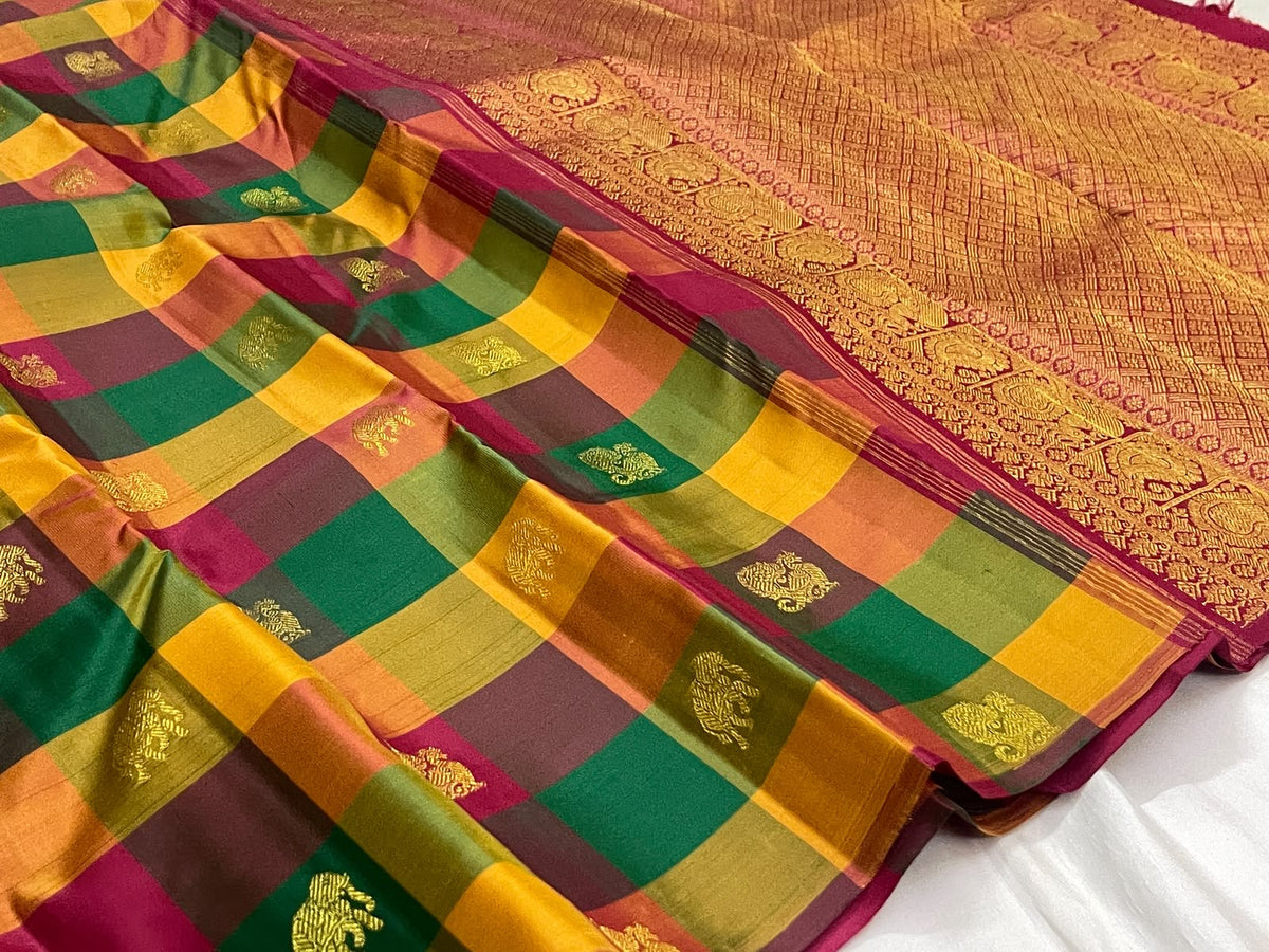 Multicolour silk body showing Kili Pachai, Mambazham and pomegranate-toned checks with spaced gold zari motifs.