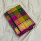 Folded Pure Kanchipuram silk saree with multicolor checks and zari woven gold border on white fabric background.