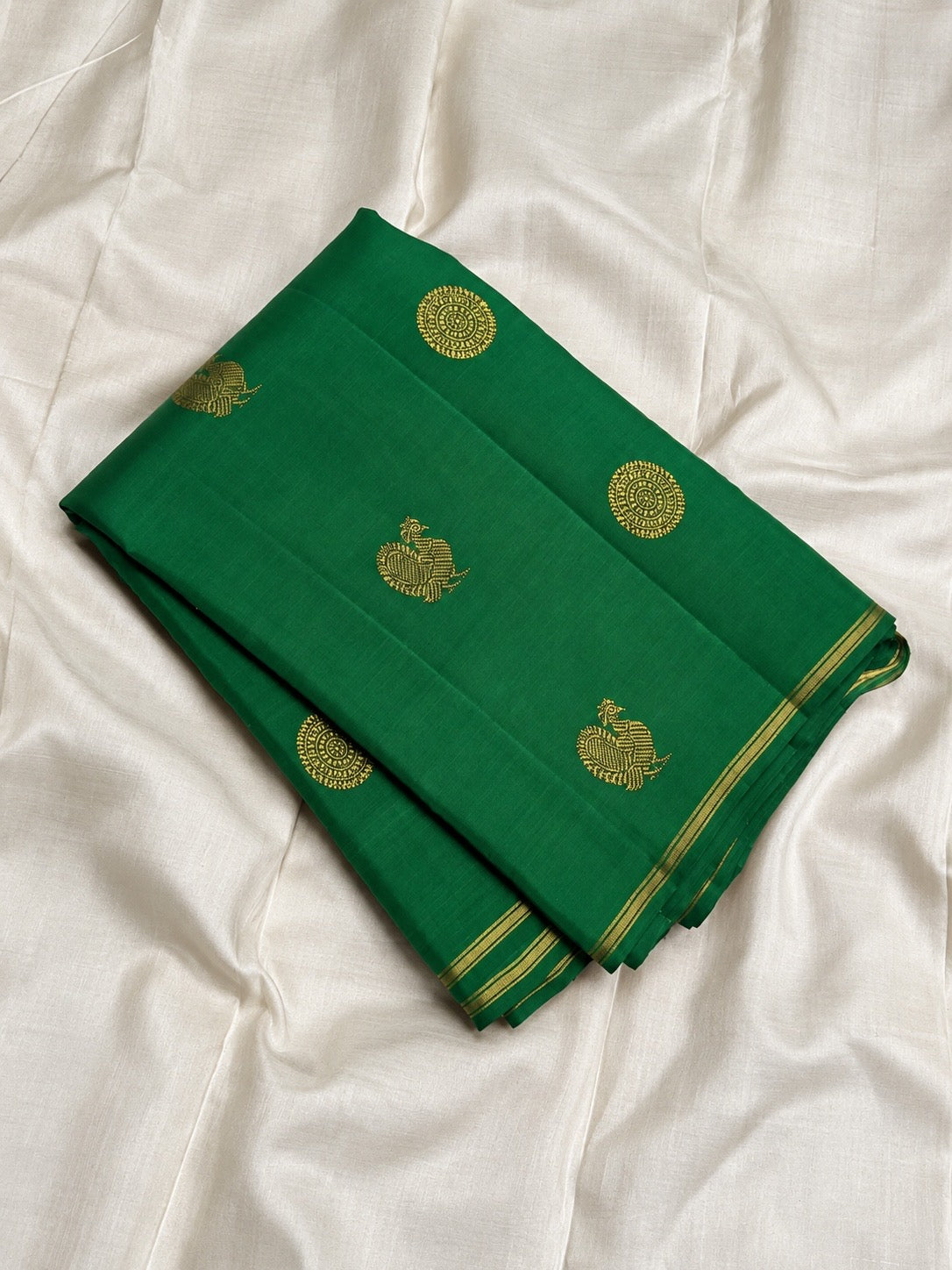 Deep Pachai Green pure silk Kanjivaram Butta saree with traditional antique-gold zari motifs.