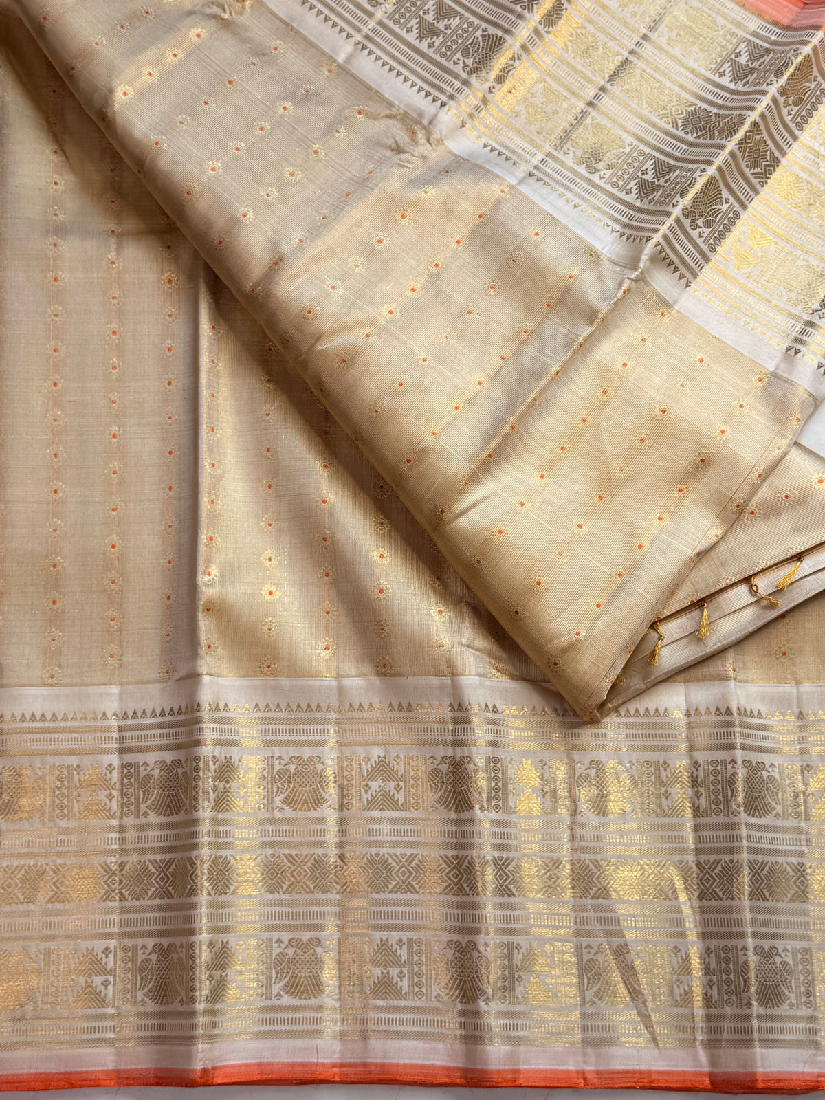 Pale gold handwoven Pure Silk Kanjeevaram Butta saree with orange Meenakari Kamalam motifs and coral-orange selvedge, full saree view