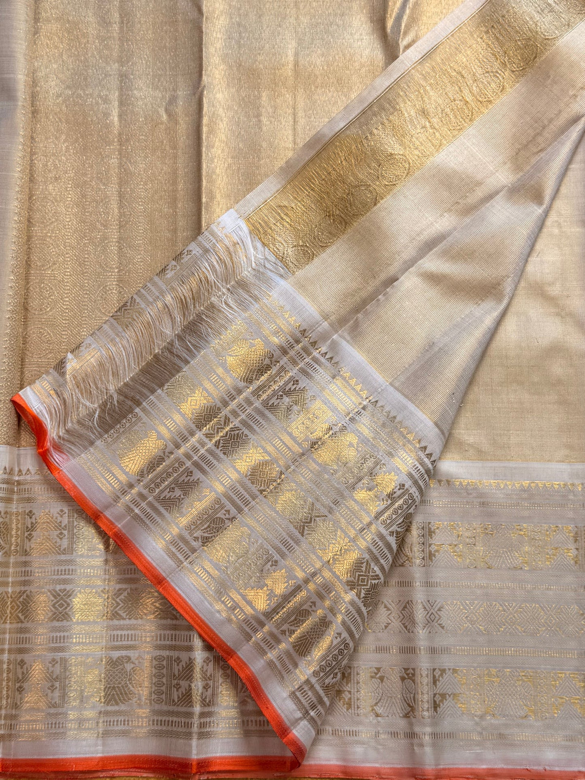 Pale gold handwoven Pure Silk Kanjeevaram Butta saree with orange Meenakari Kamalam motifs and coral-orange selvedge, pallu detail