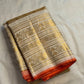Pale gold handwoven Pure Silk Kanjeevaram Butta saree with orange Meenakari Kamalam motifs and coral-orange selvedge, folded silk detail