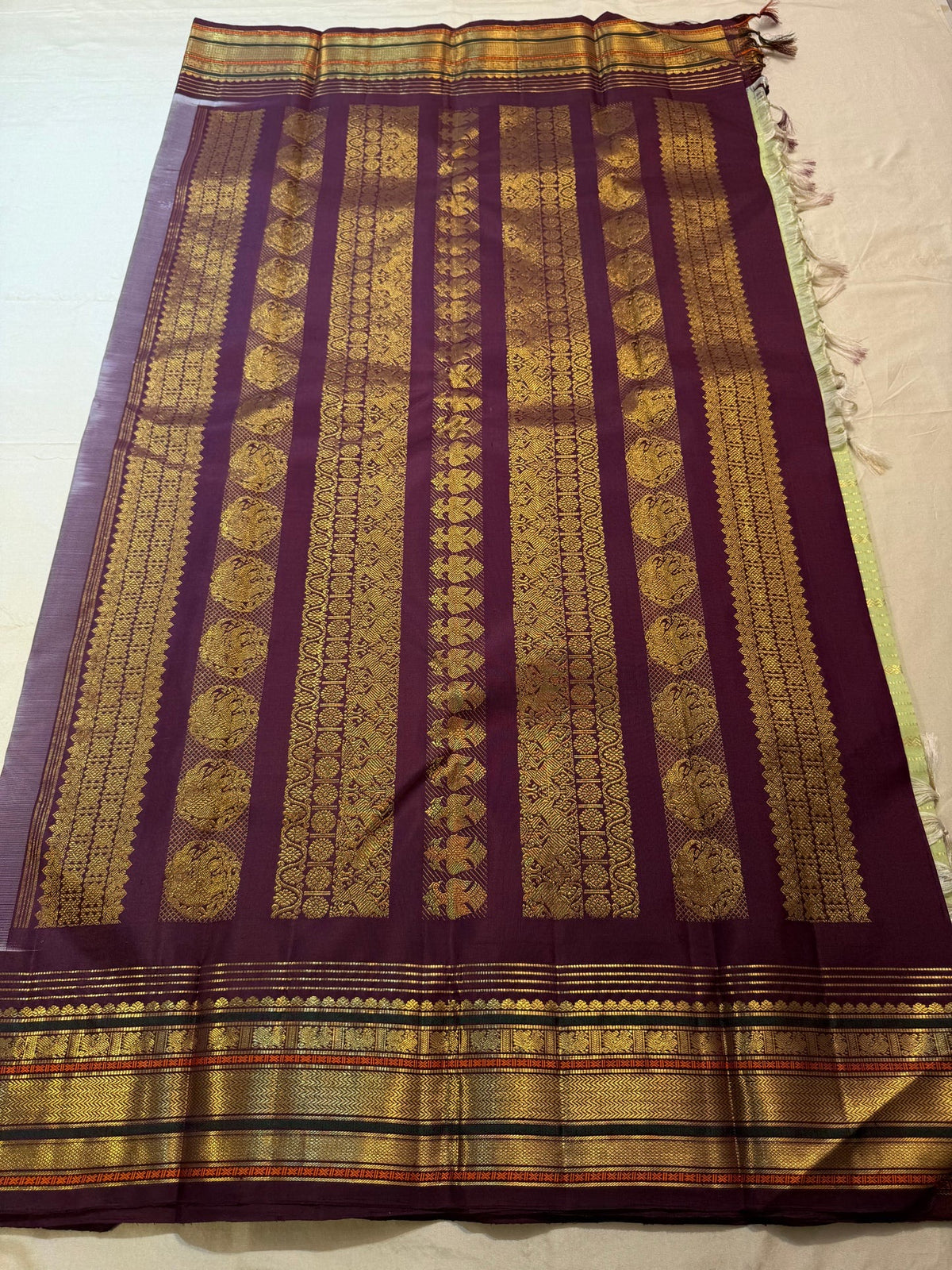 Pale green pure silk Korvai body with fine horizontal classic-gold zari lines and small geometric accent rows.