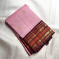 Pale Blush Pink handwoven Kanchipuram Korvai saree with gold ornamental buttas and deep Aubergine zari border.