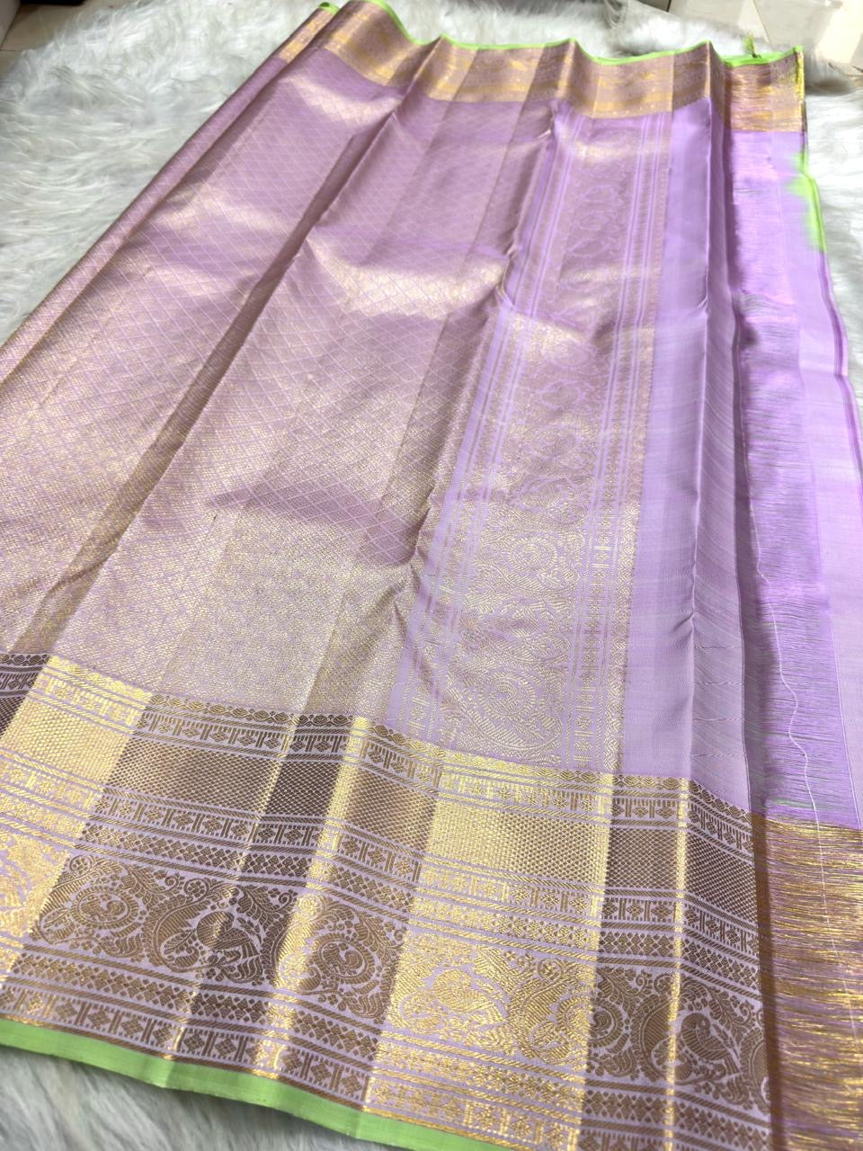 Folded Pale Pink Pure Silk Kanchipuram saree with fine Zari Kattam checks and Mint Green finishing.