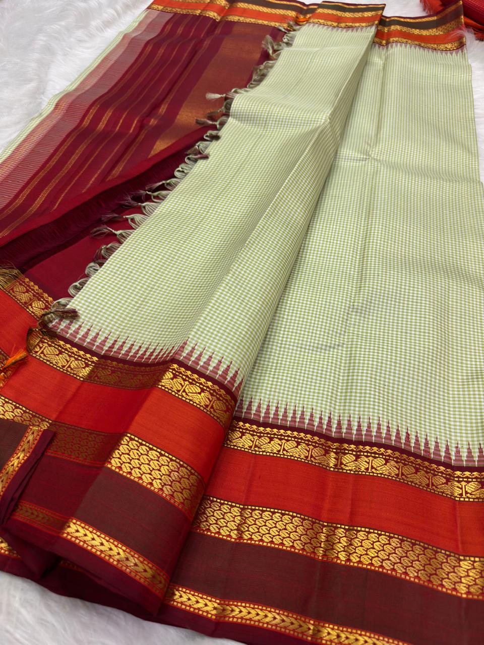 Aubergine-maroon and deep red border registers against the Pale Sage checked body.