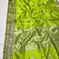 Parrot green handloom Chanderi saree with white flower motifs and softly radiant metallic detailing.