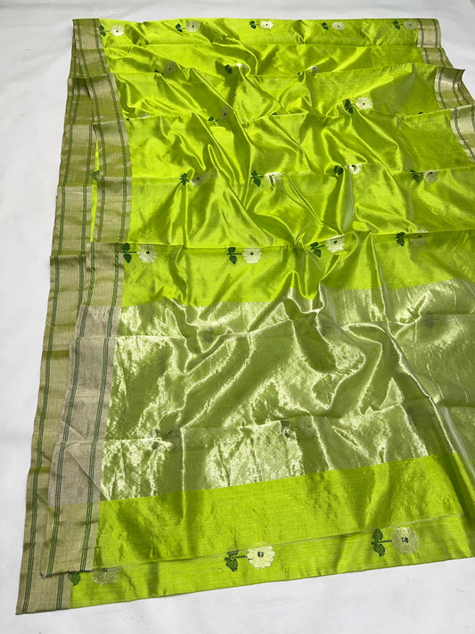 Parrot green handloom Chanderi saree with white flower motifs and softly radiant metallic detailing.