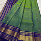 Fine gold Zari Kattam checks and buttas across the parrot green silk body