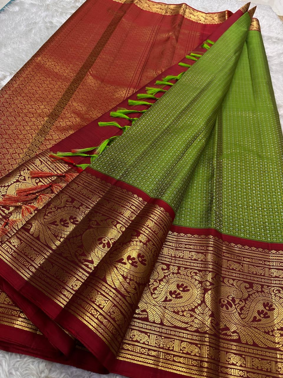 Parrot green pure silk Kanjivaram saree folded showing full body and maroon Korvai border — Idam Living