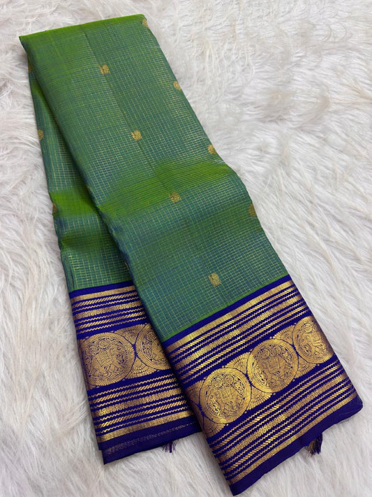 Full view of a parrot green Kanchipuram Zari Kattam silk saree with a royal blue Sorgavaasal Mayil zari border